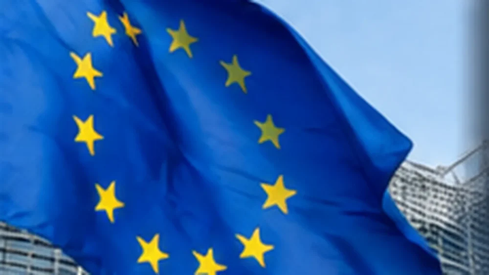 Bandeira da União Europeia junto a edifícios, enquadrando o Regulamento dos Serviços Digitais.